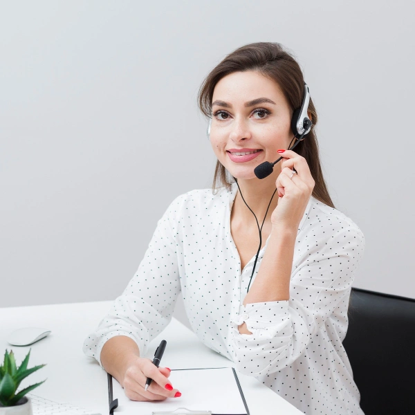 Front view smiley woman posing with headset desk